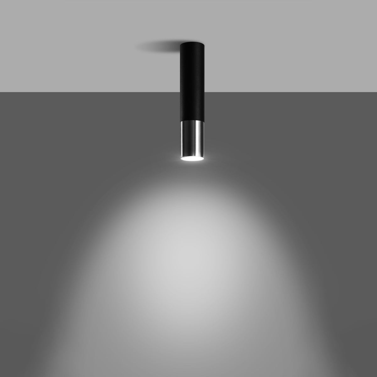 Plafonnier allumé diffusant un halo lumineux sur une paroi grise.