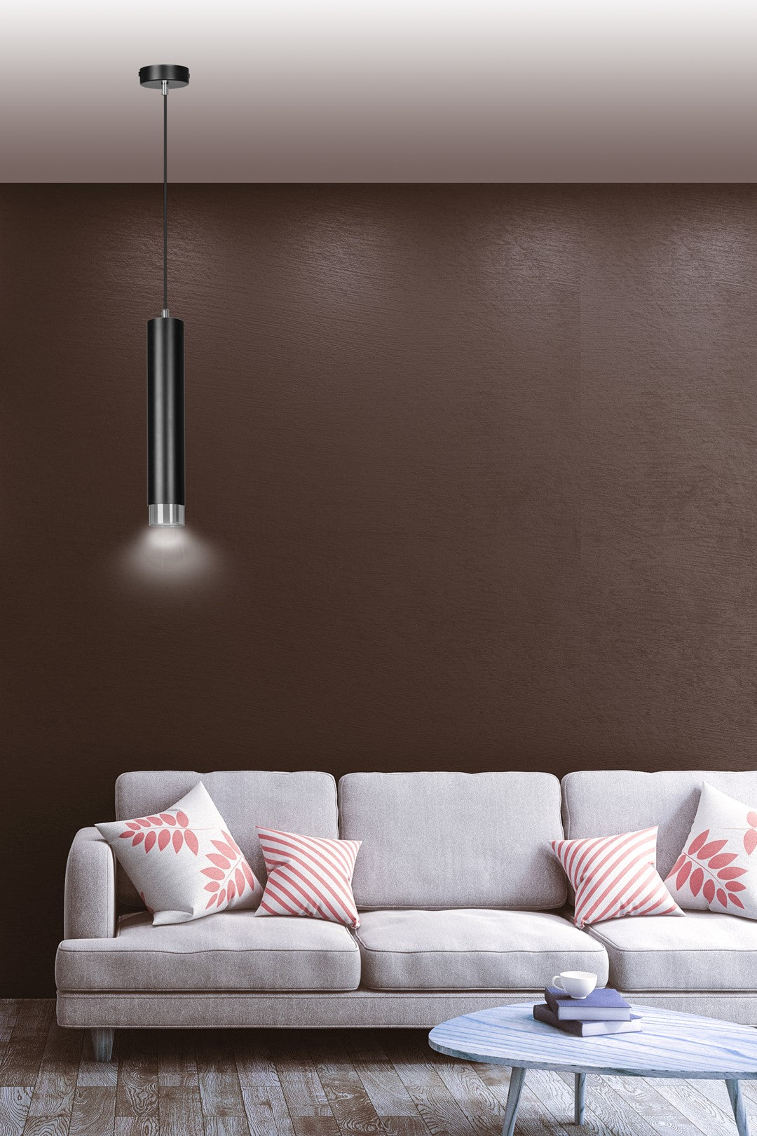 Luminaire suspendu devant un mur marron, canapé gris et coussins fleuris