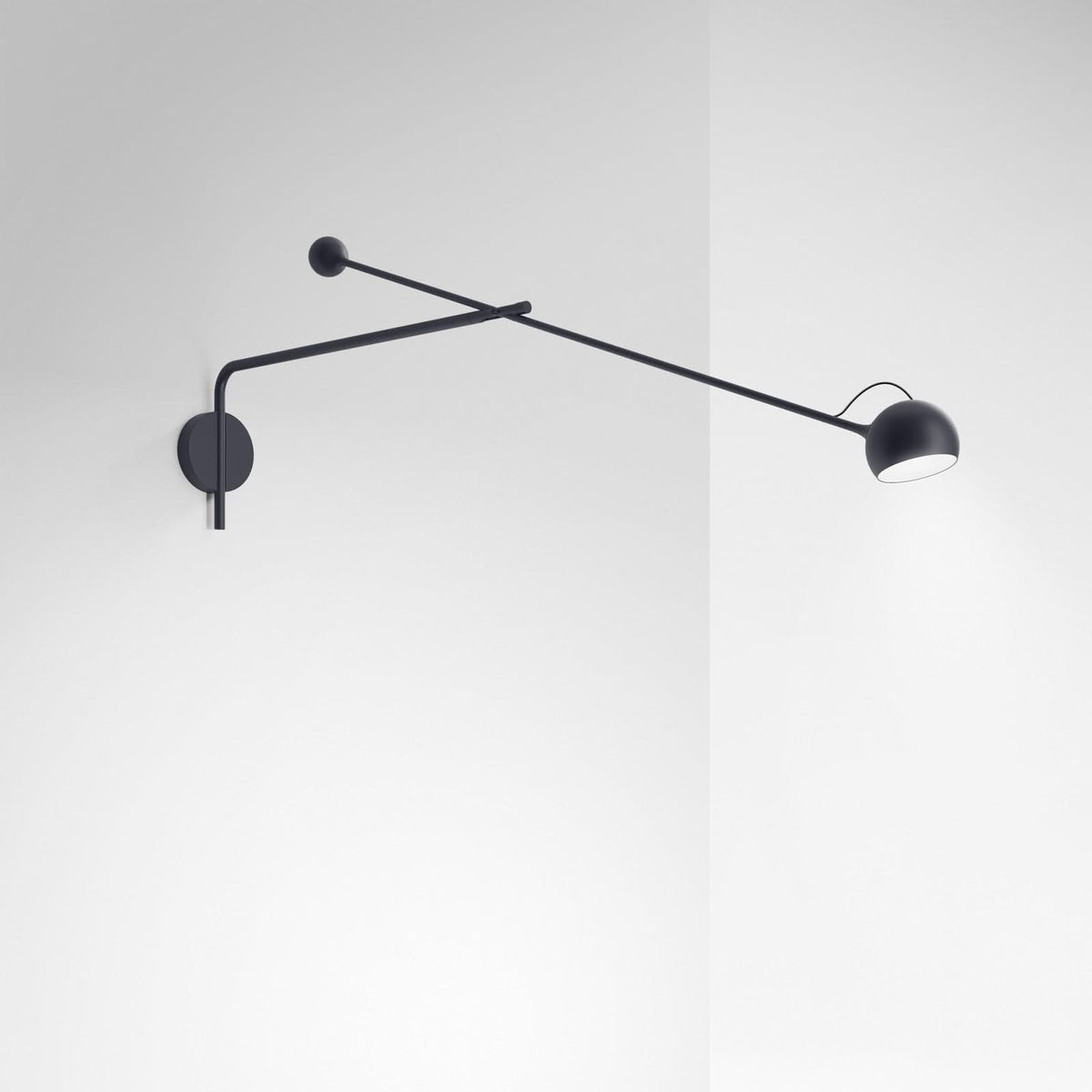 Applique murale anthracite fixée sur un mur blanc, long bras orientable et diffuseur.