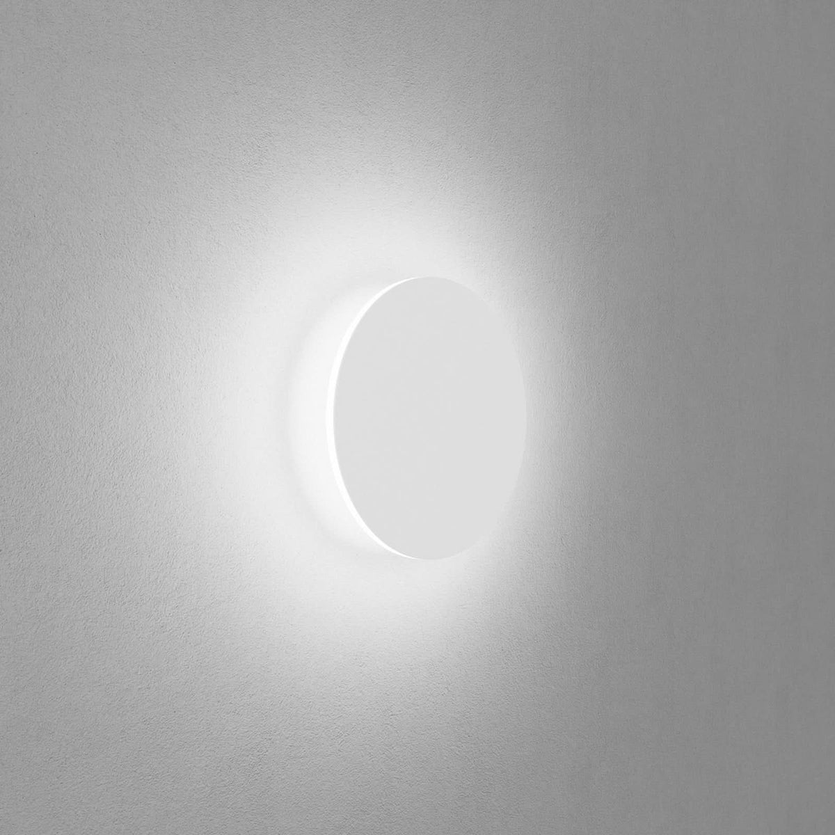 Vue de profil du luminaire fixé au mur, halo lumineux diffus