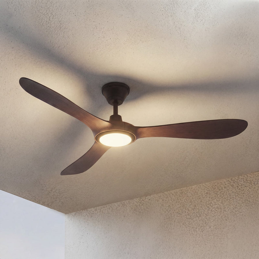 Vue en contre-plongée d'un ventilateur de plafond à trois pales bois et lumière centrale.