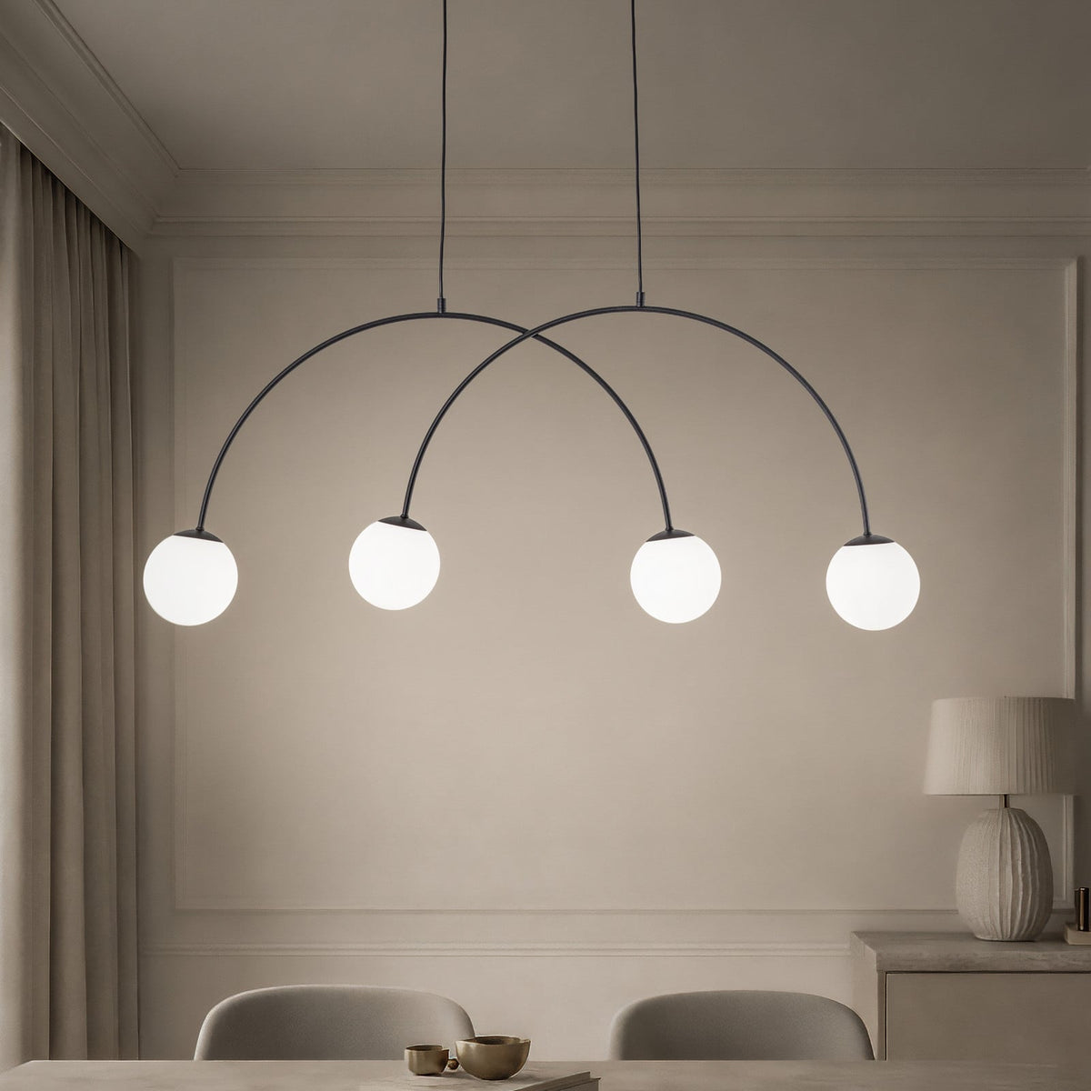 Suspension noire à quatre globes blancs allumés au-dessus d’une table de salle à manger.