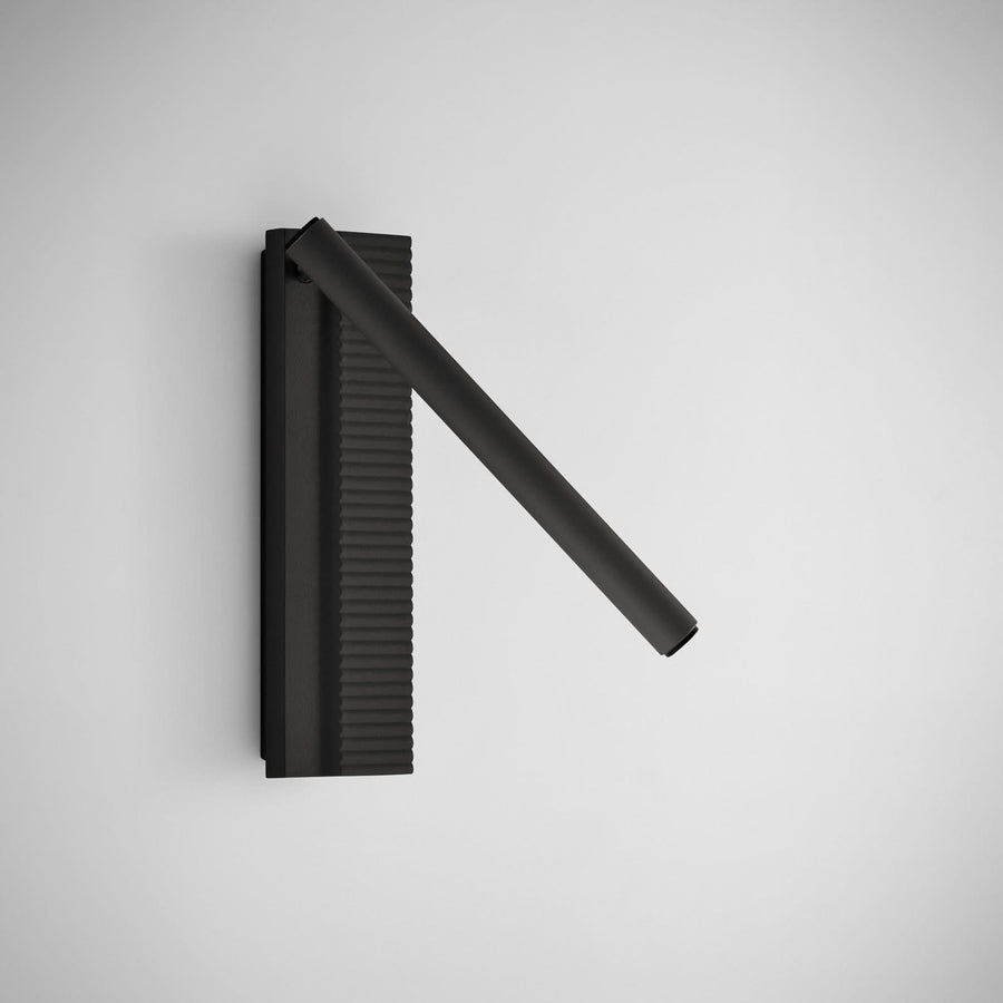 Vue de face de l’applique noire, plaque verticale striée et bras cylindrique.
