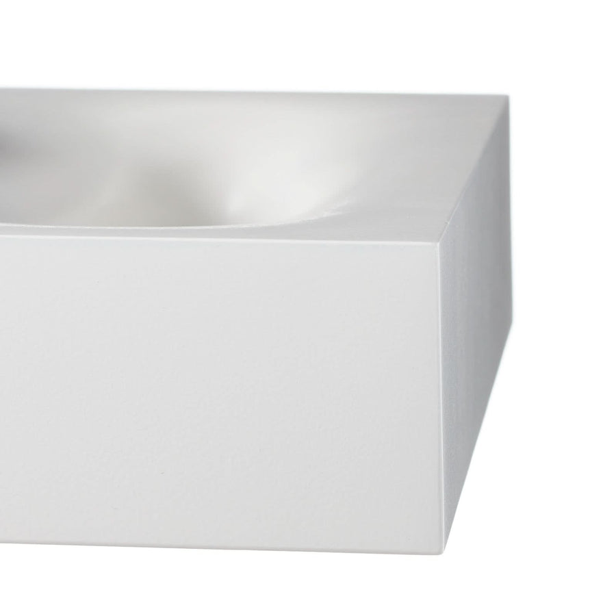 Gros plan sur l'angle arrondi et la finition mate blanche du luminaire.