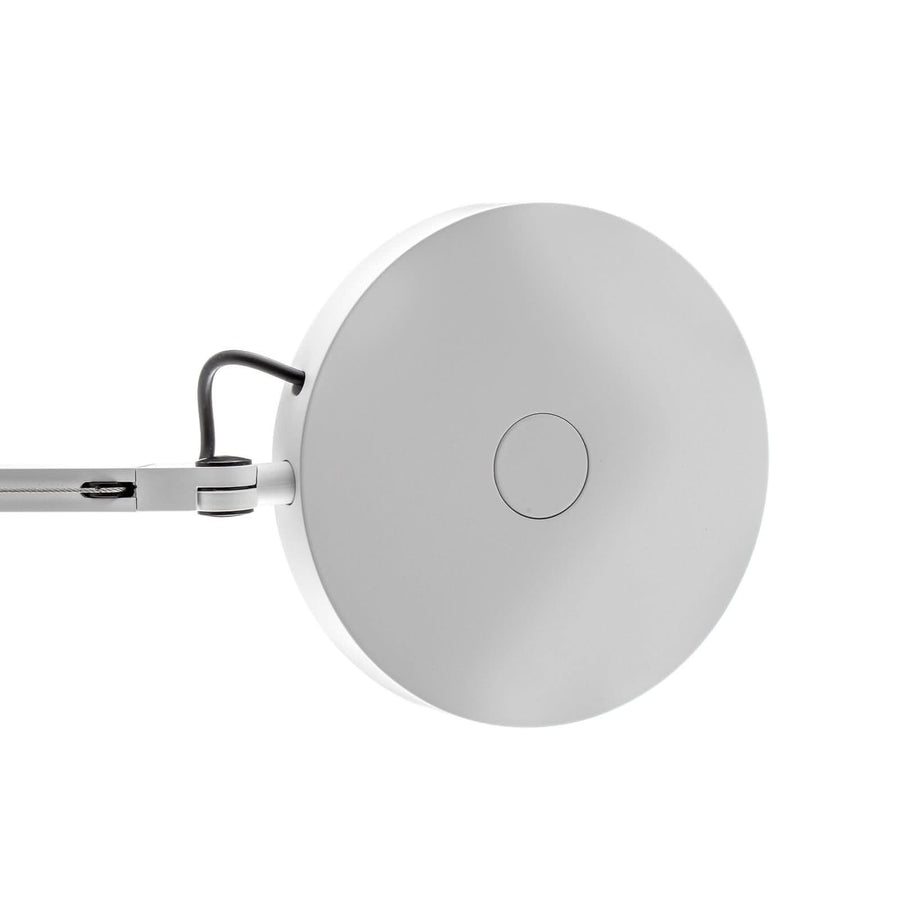 Tête circulaire blanche photographiée de face, avec petit bouton central et attache.
