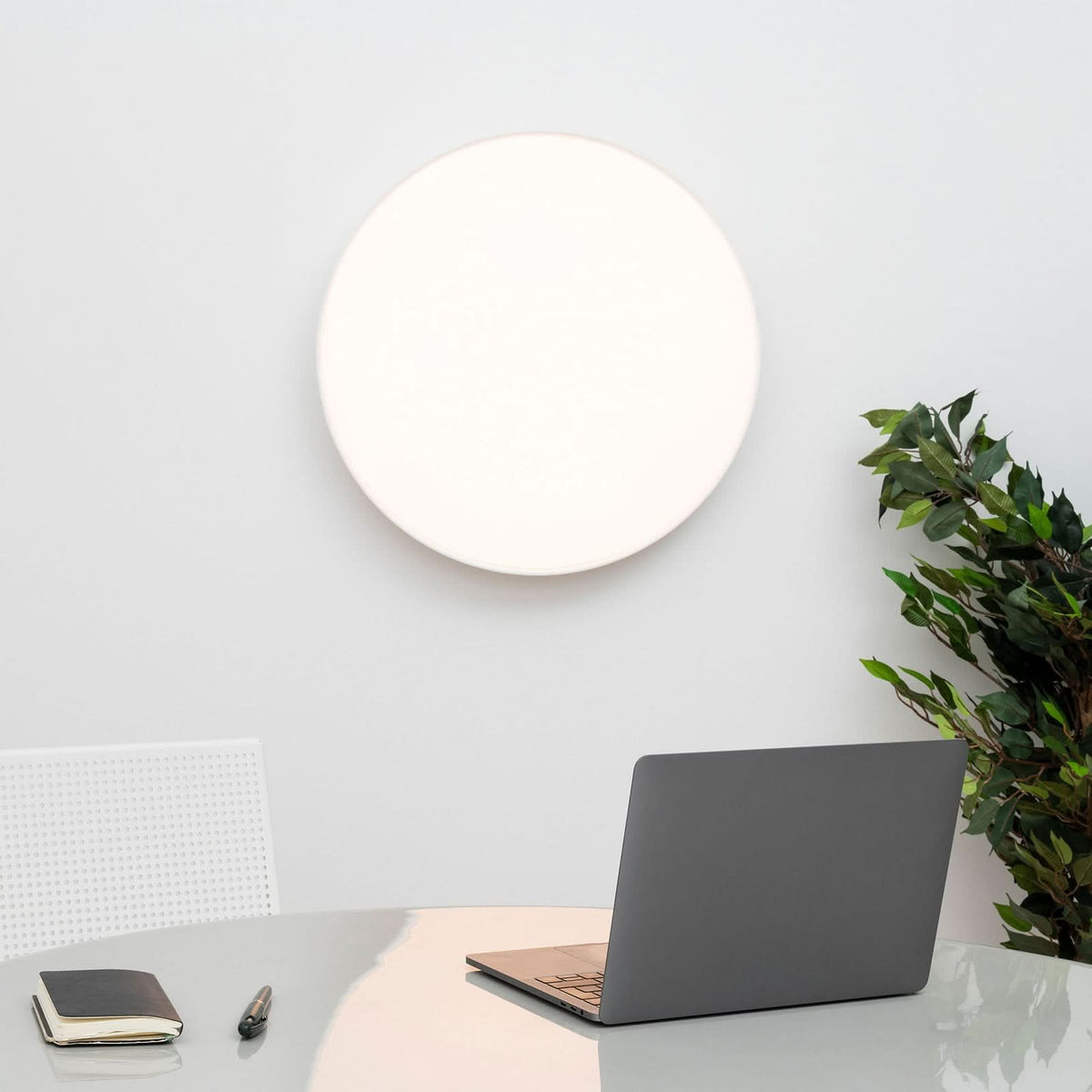 Applique murale LED ronde blanche au-dessus d'un bureau avec ordinateur portable.