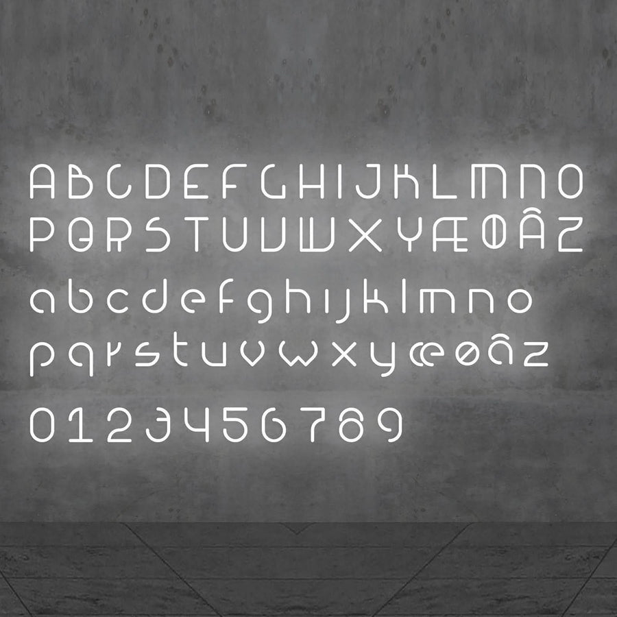 Alphabet complet en lettres lumineuses blanches, chiffres inclus, sur mur gris