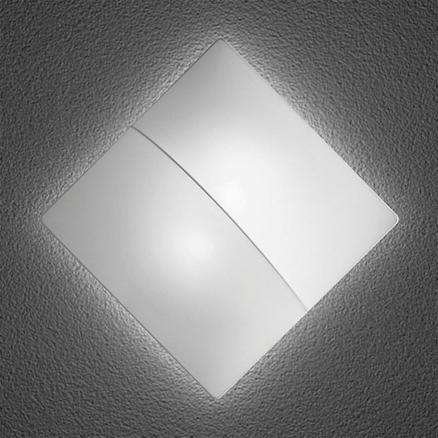 Applique murale carrée blanche allumée, fixée sur un mur texturé gris foncé.