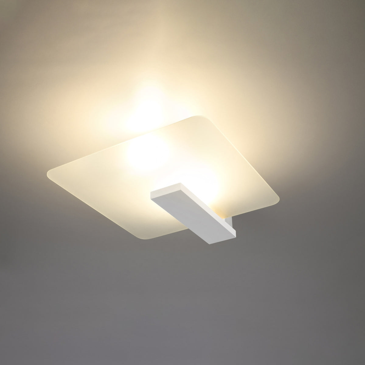 Plafonnier allumé diffusant une lumière chaude sur le plafond et la pièce