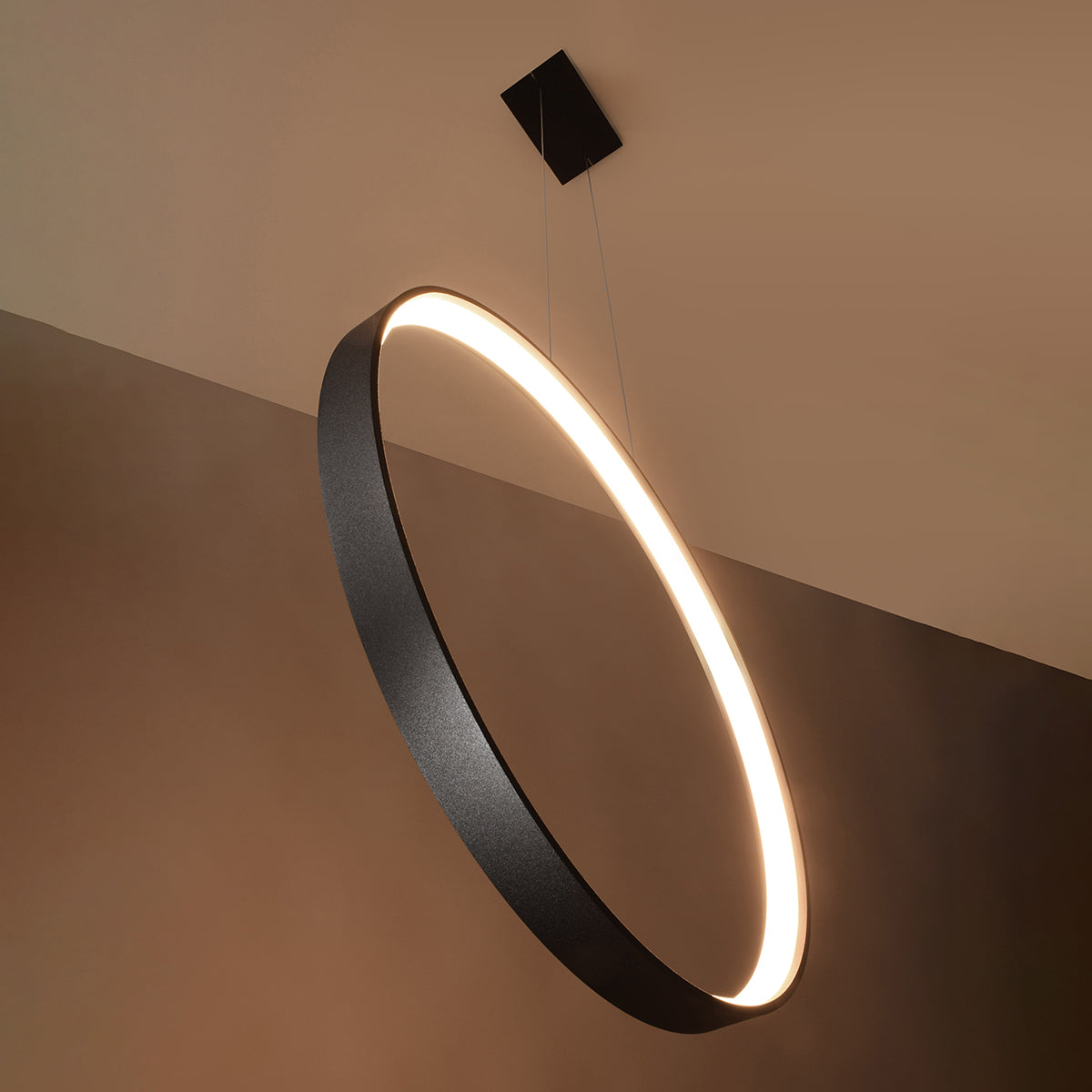 Mise en ambiance d'un anneau lumineux incliné éclairant un intérieur aux tons chauds