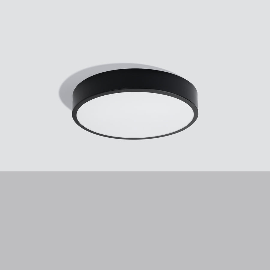 Luminaire fixé au plafond gris, vue en contre-plongée montrant le cerclage noir