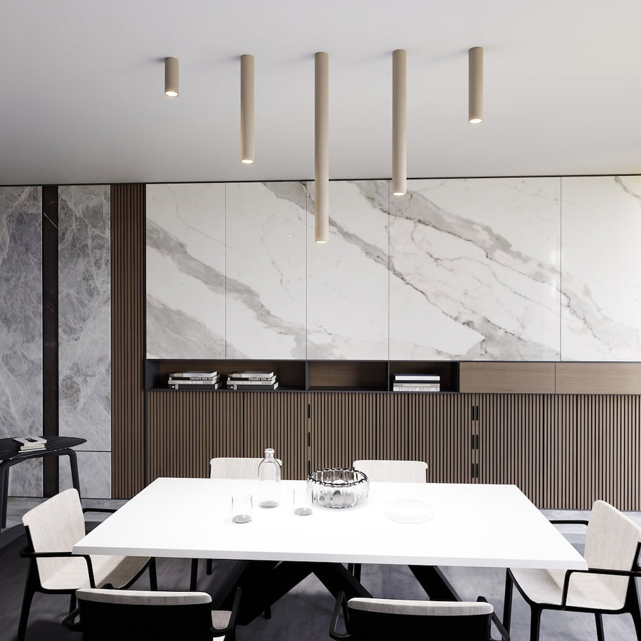 Vue d'ensemble d'une salle à manger avec cinq cylindres beige alignés au plafond.