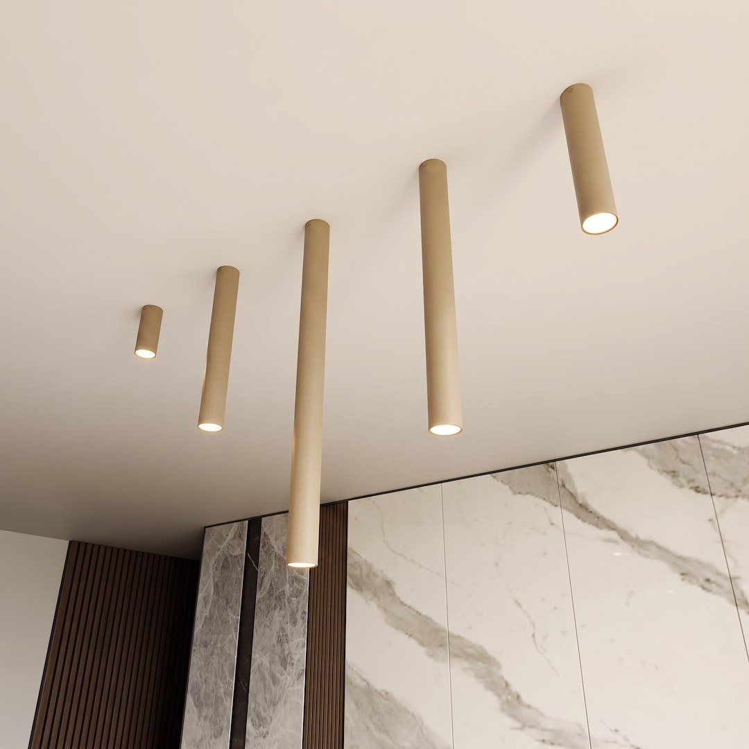 Gros plan sur plusieurs cylindres beige fixés au plafond, éclairant une pièce.