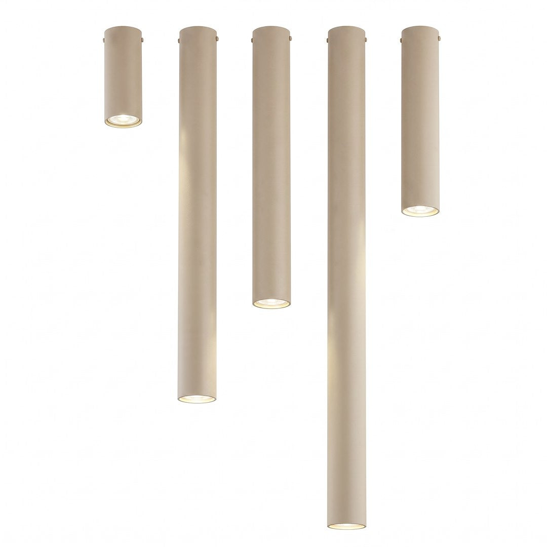 Vue de face, cinq cylindres beige de tailles variées sur fond blanc.