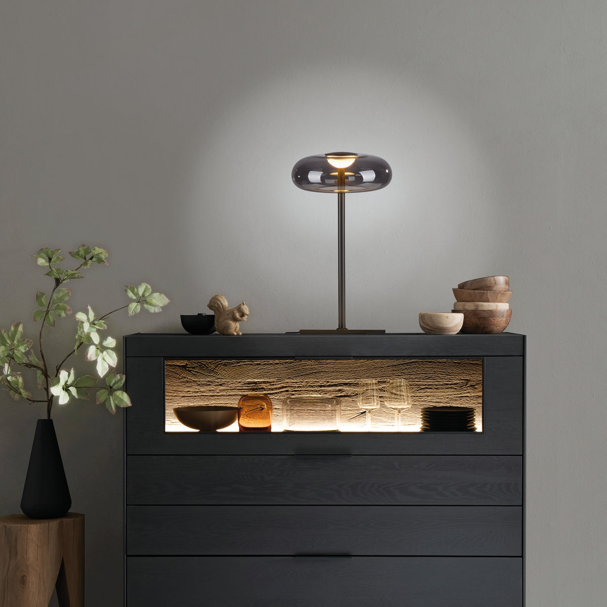 Mise en ambiance sur une commode sombre avec objets décoratifs
