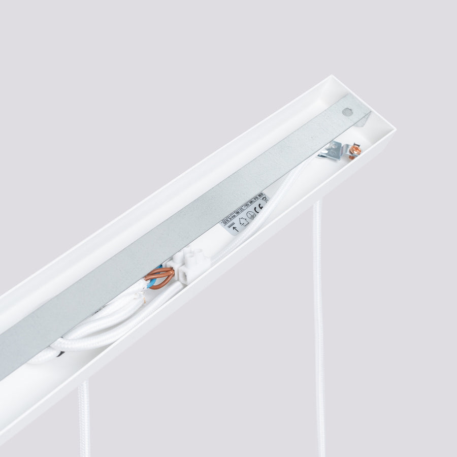 Détail technique de la platine de fixation avec câblage, bornier et étiquettes de conformité.