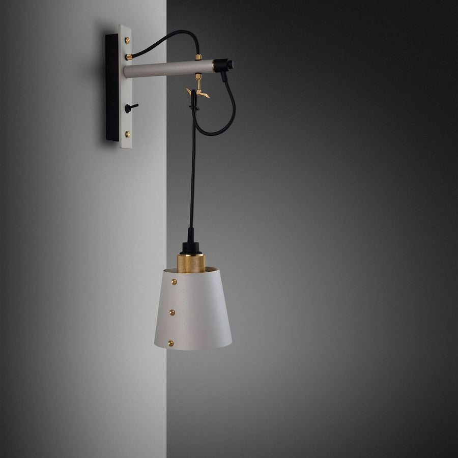 Vue de profil de l’applique fixée au mur, câble noir pendant et abat-jour conique.