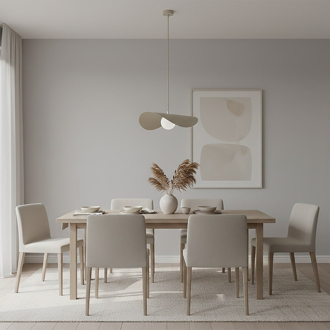 Suspension au-dessus d'une table à manger en bois, chaises claires et vase de plumes