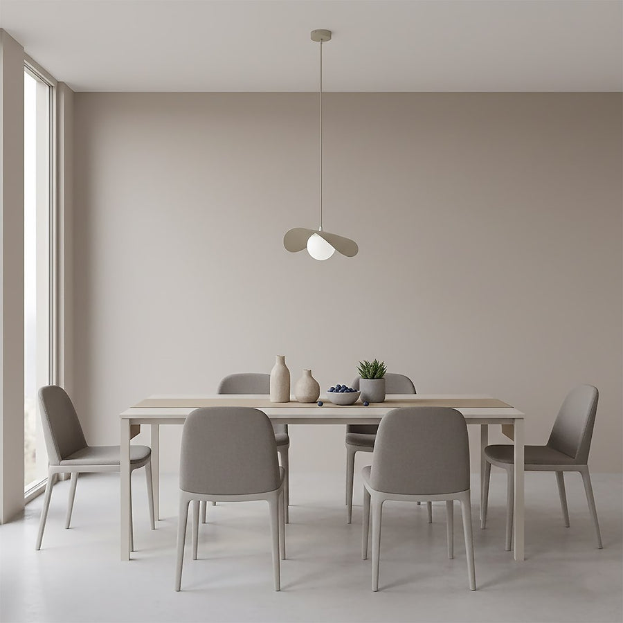 Suspension installée au-dessus d'une table à manger en bois clair, intérieur beige épuré.