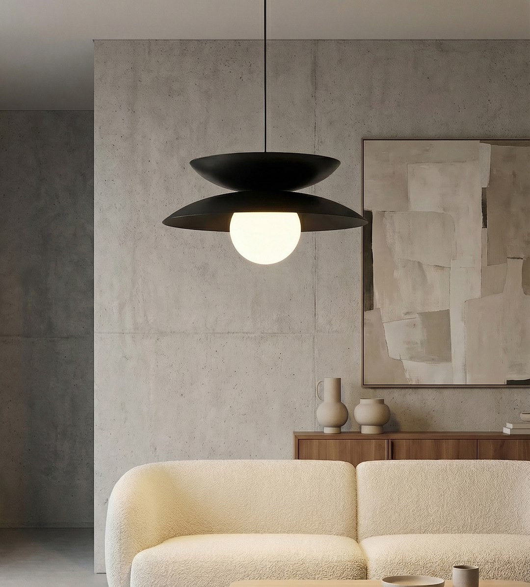 Ambiance intérieure, luminaire suspendu devant un mur béton et un tableau