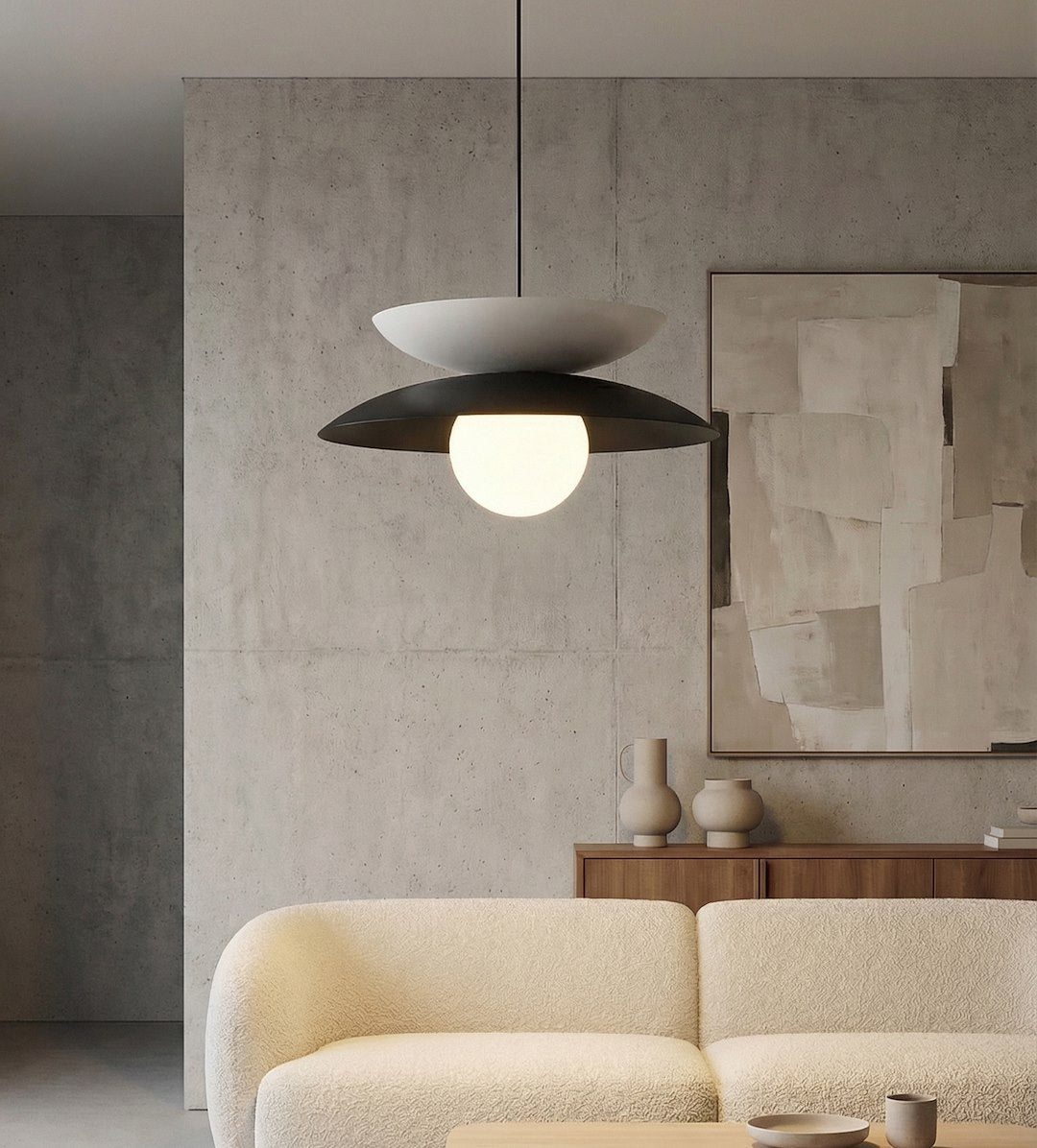 Intérieur contemporain avec mur béton, suspension allumée diffusant une lumière chaude.