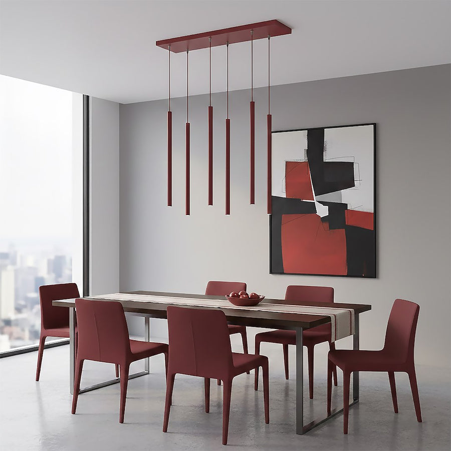 Suspension rouge installée dans un séjour, table en bois, chaises bordeaux et tableau abstrait.
