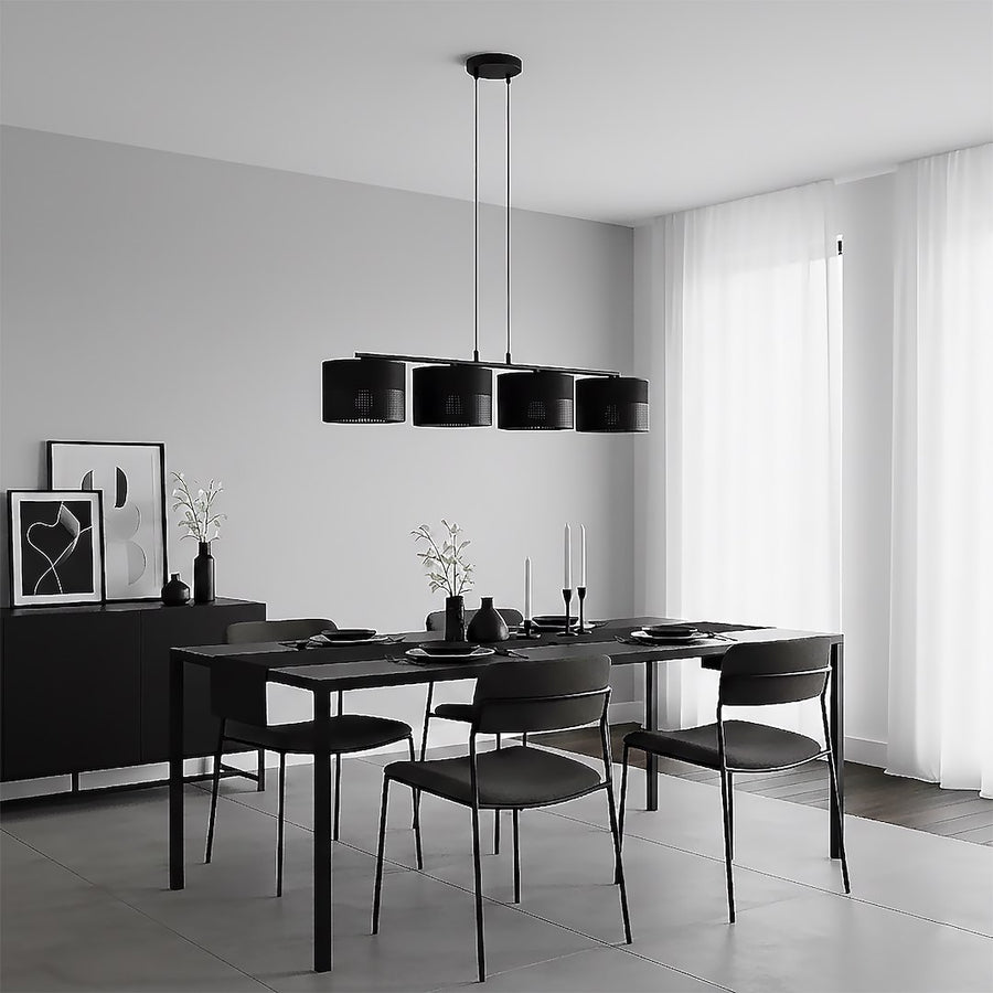 Salle à manger minimaliste noire et blanche, suspension à quatre lumières au-dessus de la table dressée.