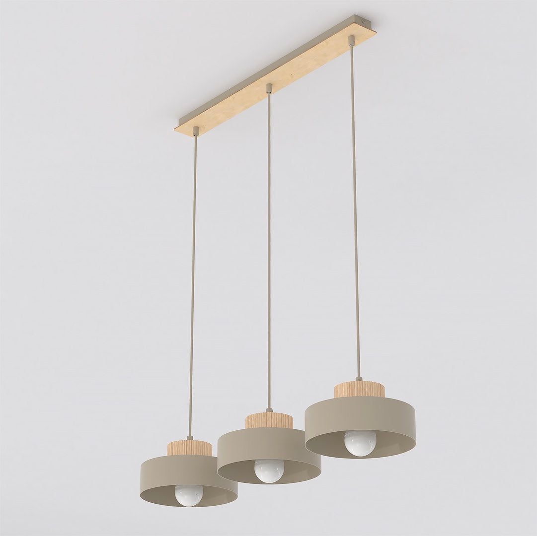 Suspension beige à trois abat-jours cylindriques alignés sur une barre en bois clair.