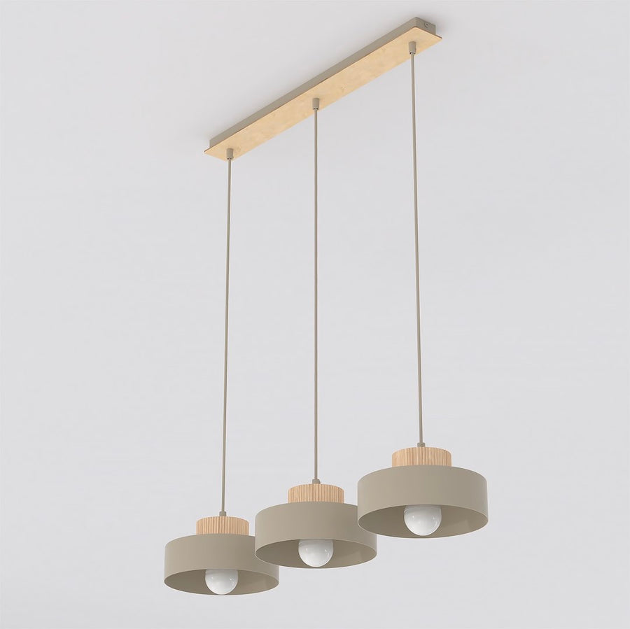 Suspension beige à trois abat-jours cylindriques alignés sur une barre en bois clair.