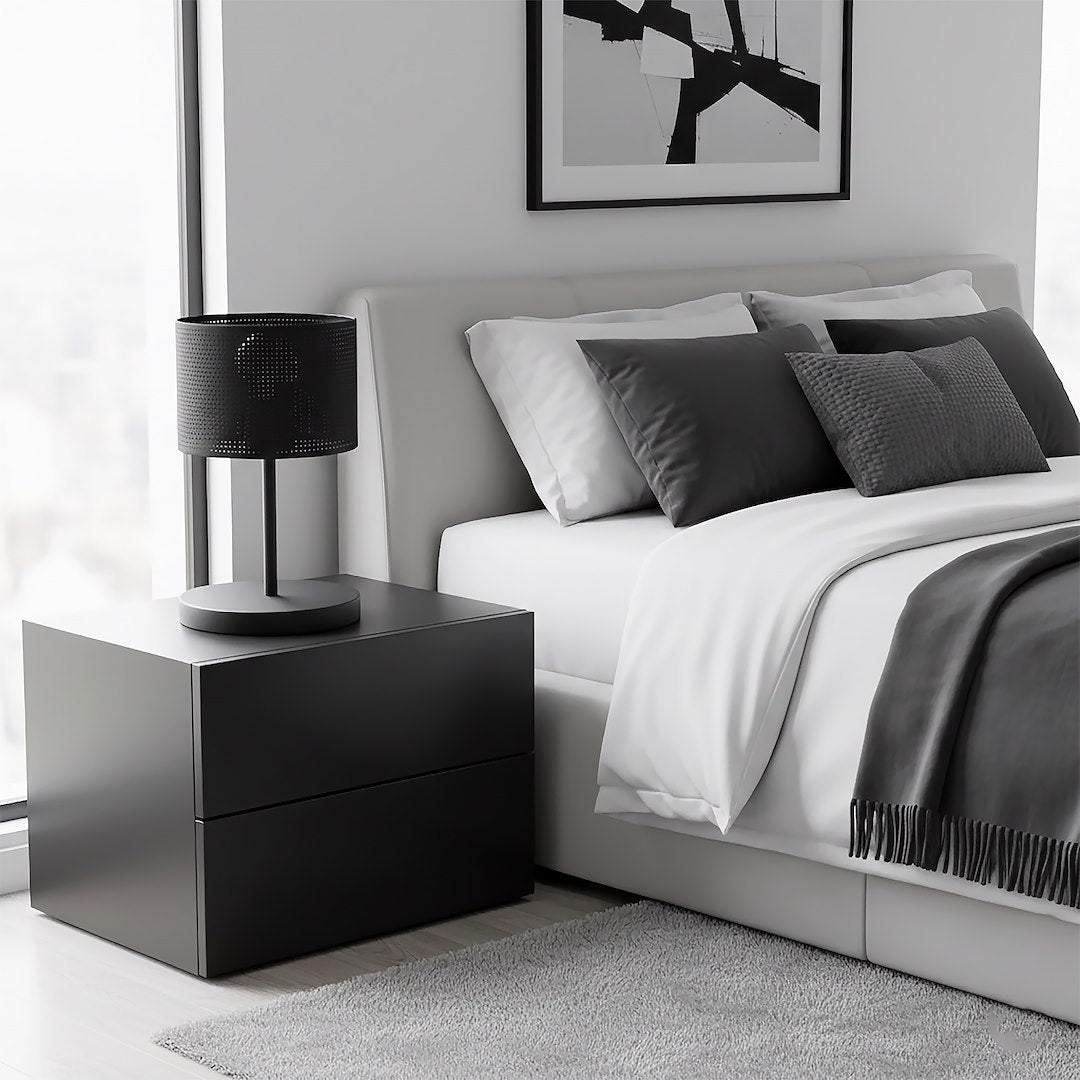 Lampe de chevet noire sur meuble noir dans une chambre grise et blanche.