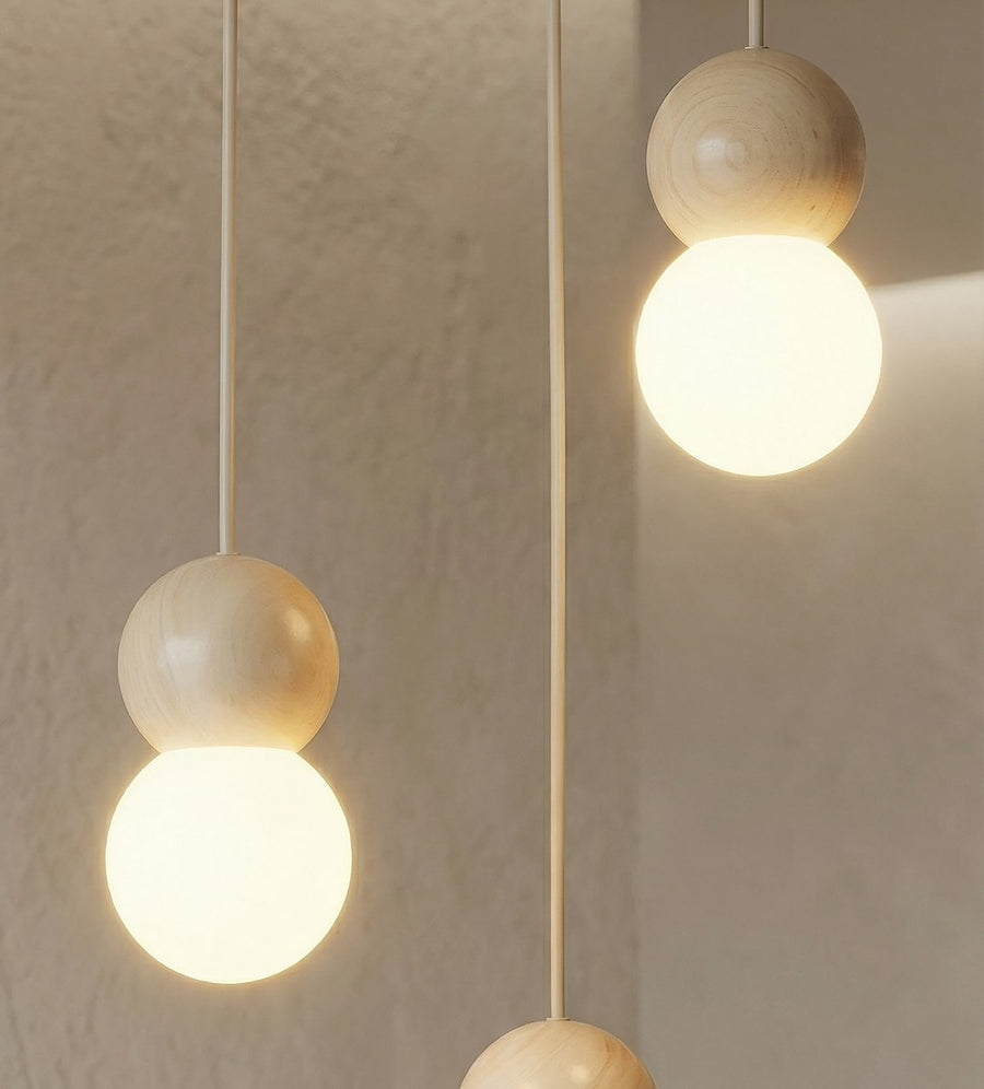 Gros plan sur les boules de bois tourné et diffuseurs verre opale allumés.