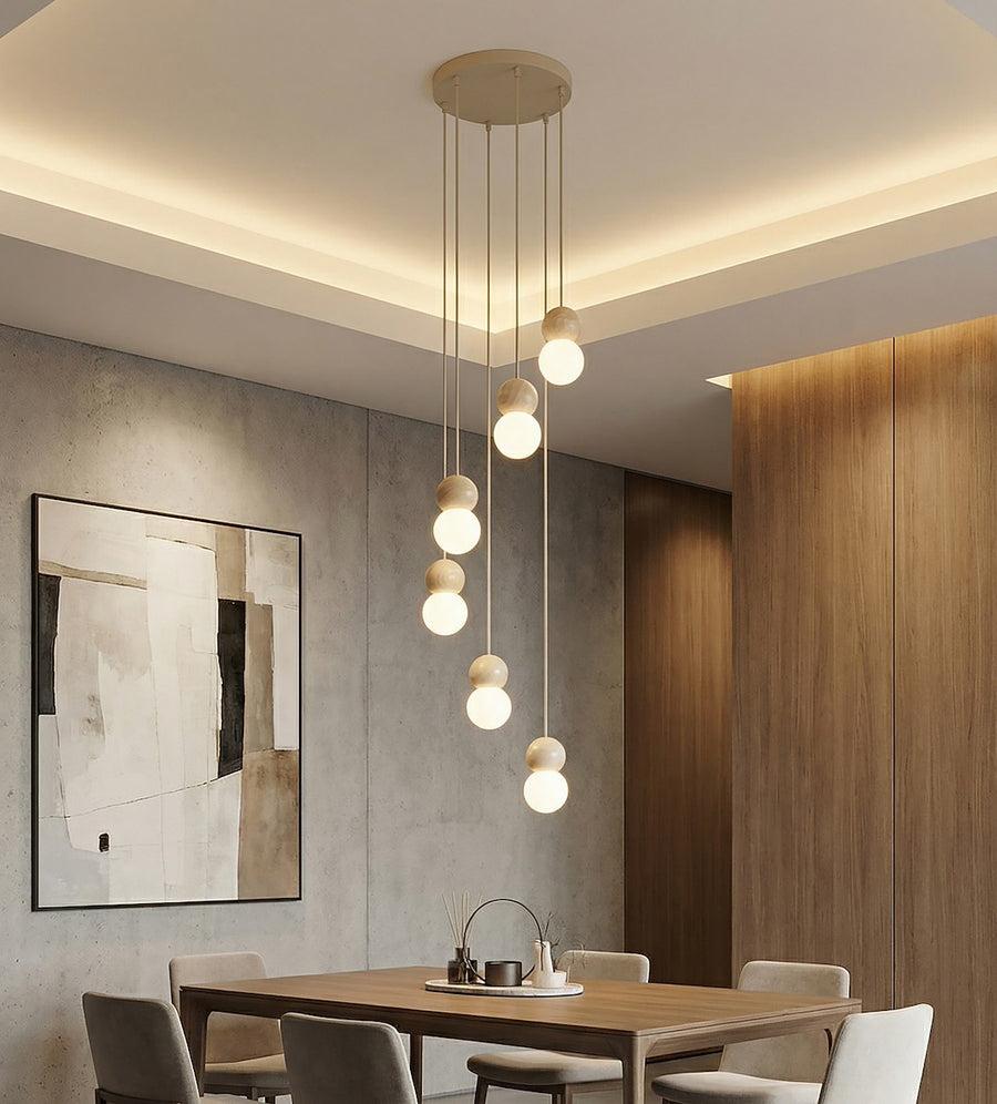 Suspension allumée au-dessus d'une table en bois dans une salle à manger béton