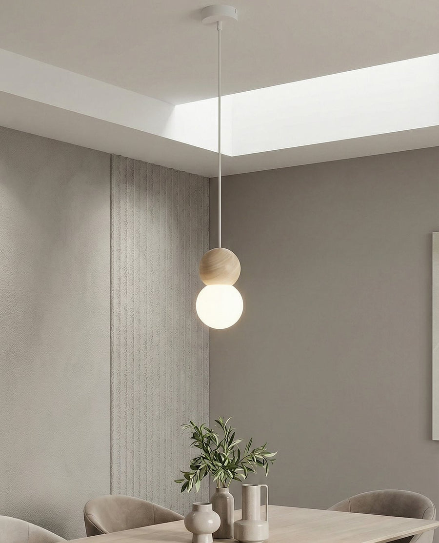 Suspension allumée devant mur gris et panneau strié, intérieur minimaliste