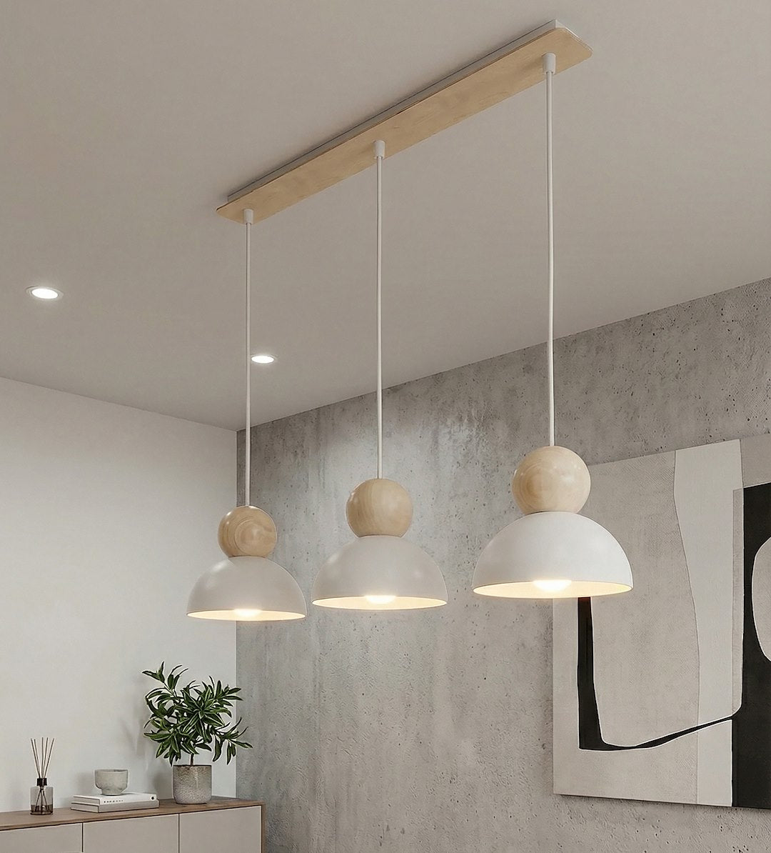 Suspension blanche et bois suspendue devant un mur béton avec plante.