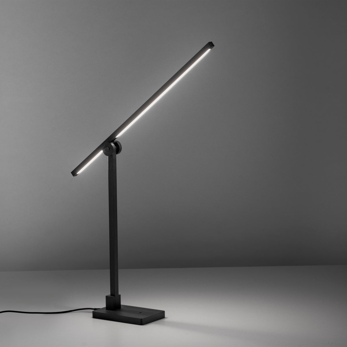 Ambiance sombre, lampe allumée de profil avec câble d'alimentation visible