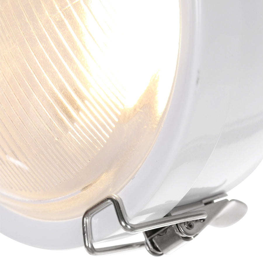 Gros plan sur la lentille striée et les attaches métalliques du diffuseur blanc.