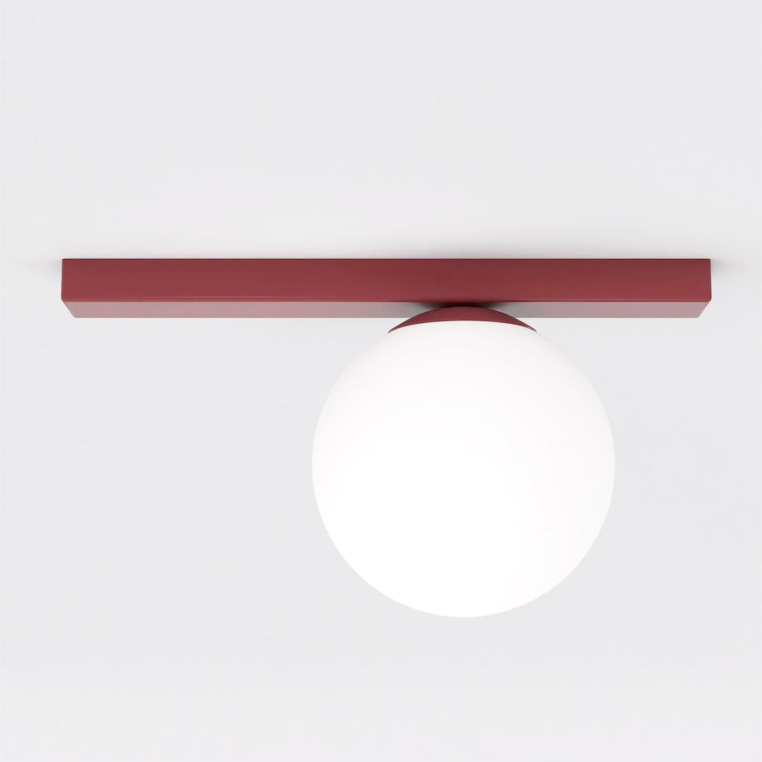 Vue de face du plafonnier rouge à diffuseur sphérique blanc sur fond neutre