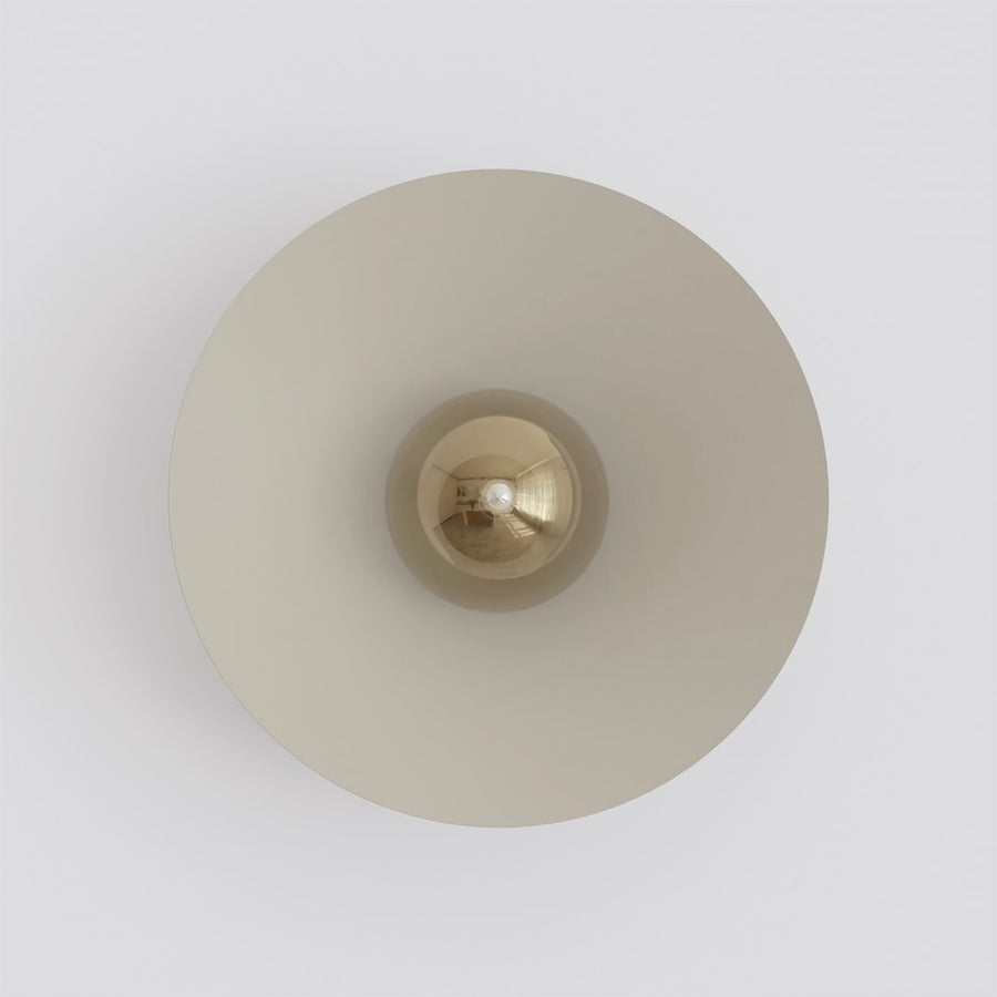Vue de face de l’applique murale, abat-jour rond beige et ampoule centrale.