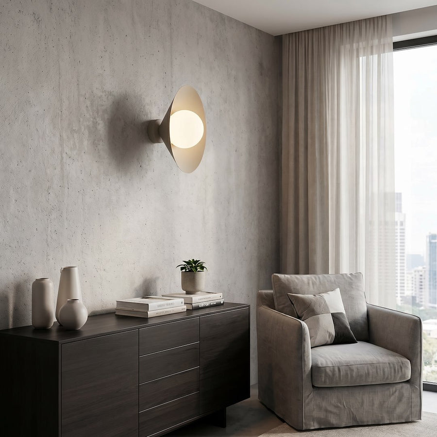 Mise en ambiance dans un salon moderne, applique allumée sur un mur en béton.
