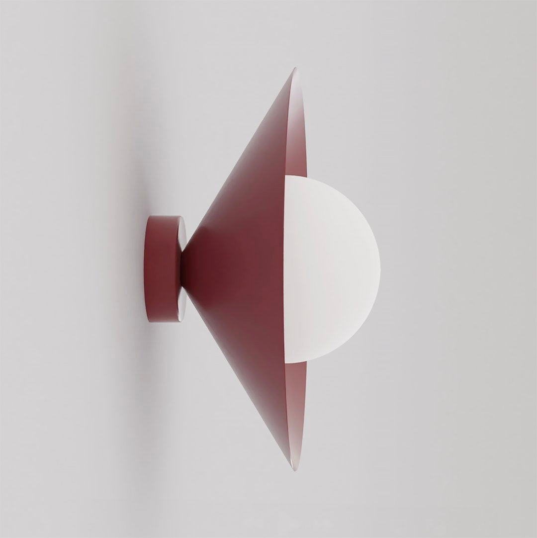 Vue de profil de l'applique murale bordeaux avec abat-jour conique et sphère blanche.