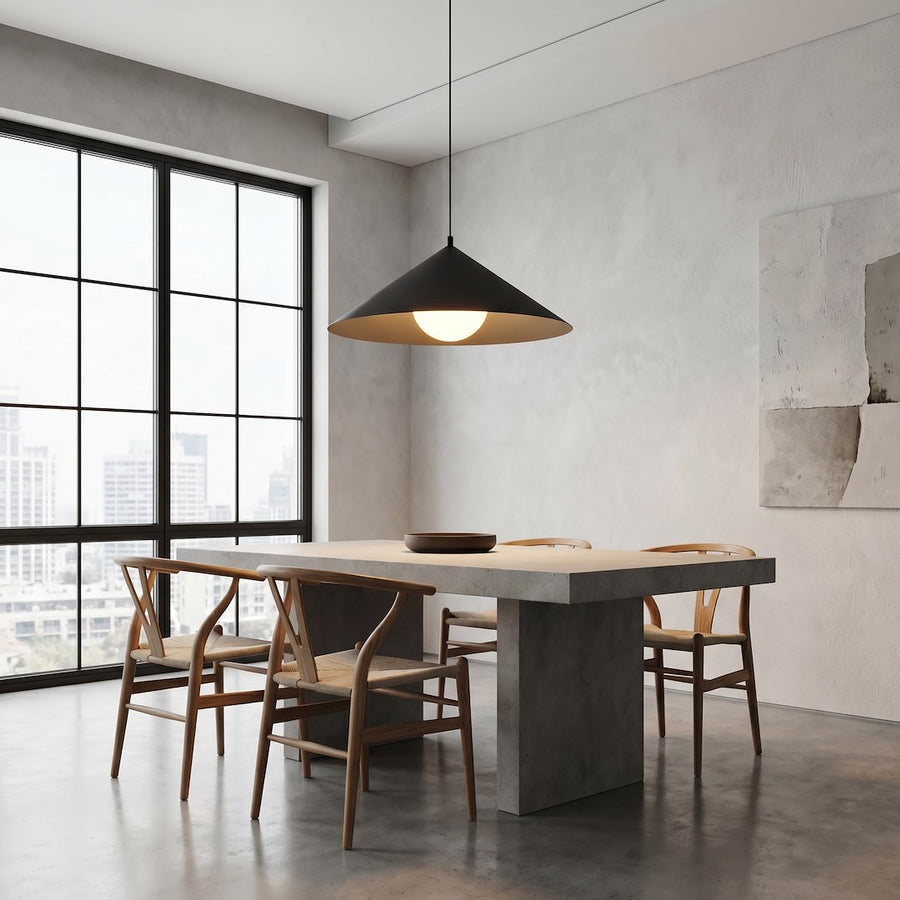 Suspension noire au-dessus d'une table en béton, chaises en bois et grande fenêtre