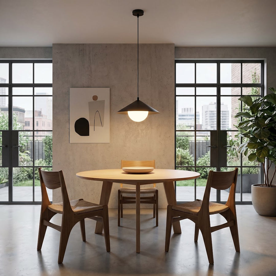 Luminaire suspendu au-dessus d'une table ronde en bois clair près d'une grande baie