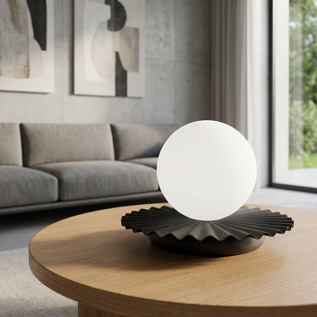 Lampe posée sur table ronde en chêne devant un canapé gris clair
