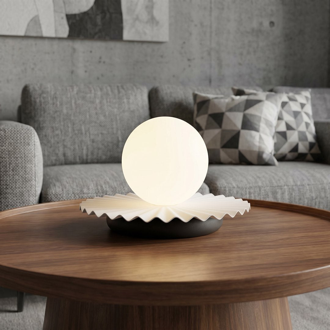 Lampe allumée sur table basse en bois devant un canapé gris, ambiance salon.