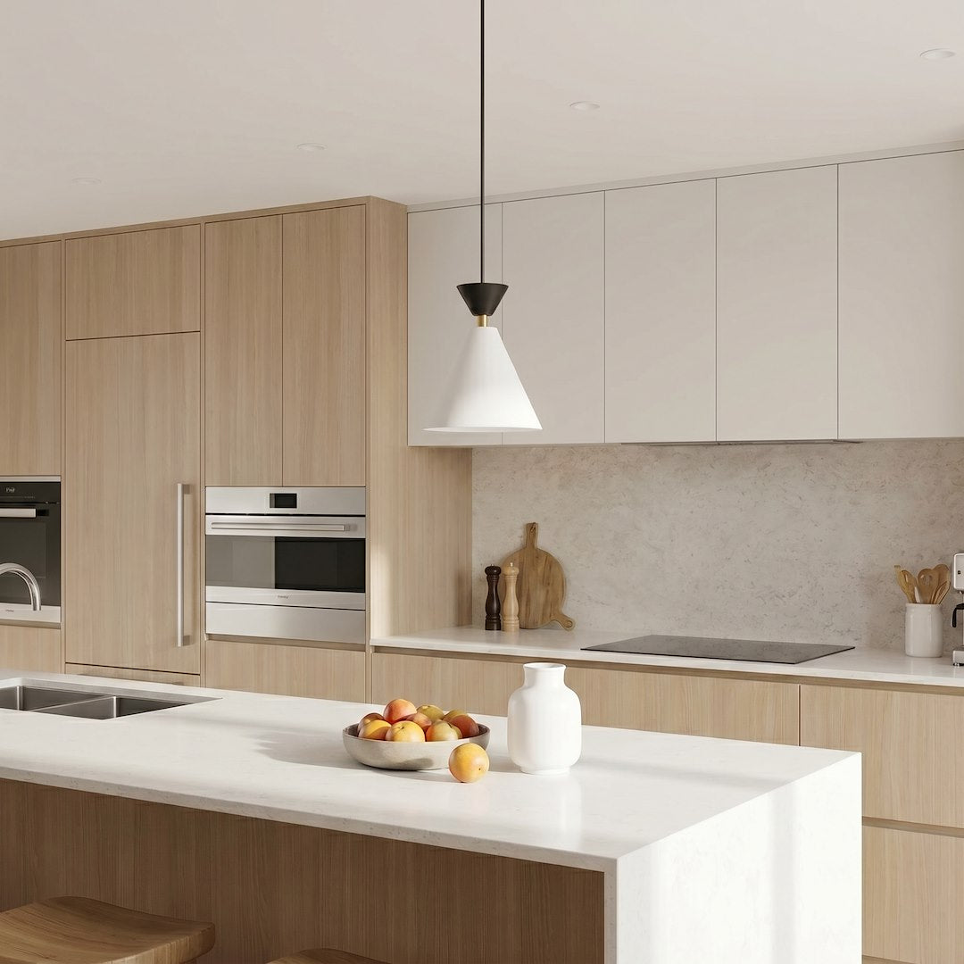 Suspension installée au-dessus d'un îlot de cuisine en bois clair et blanc.