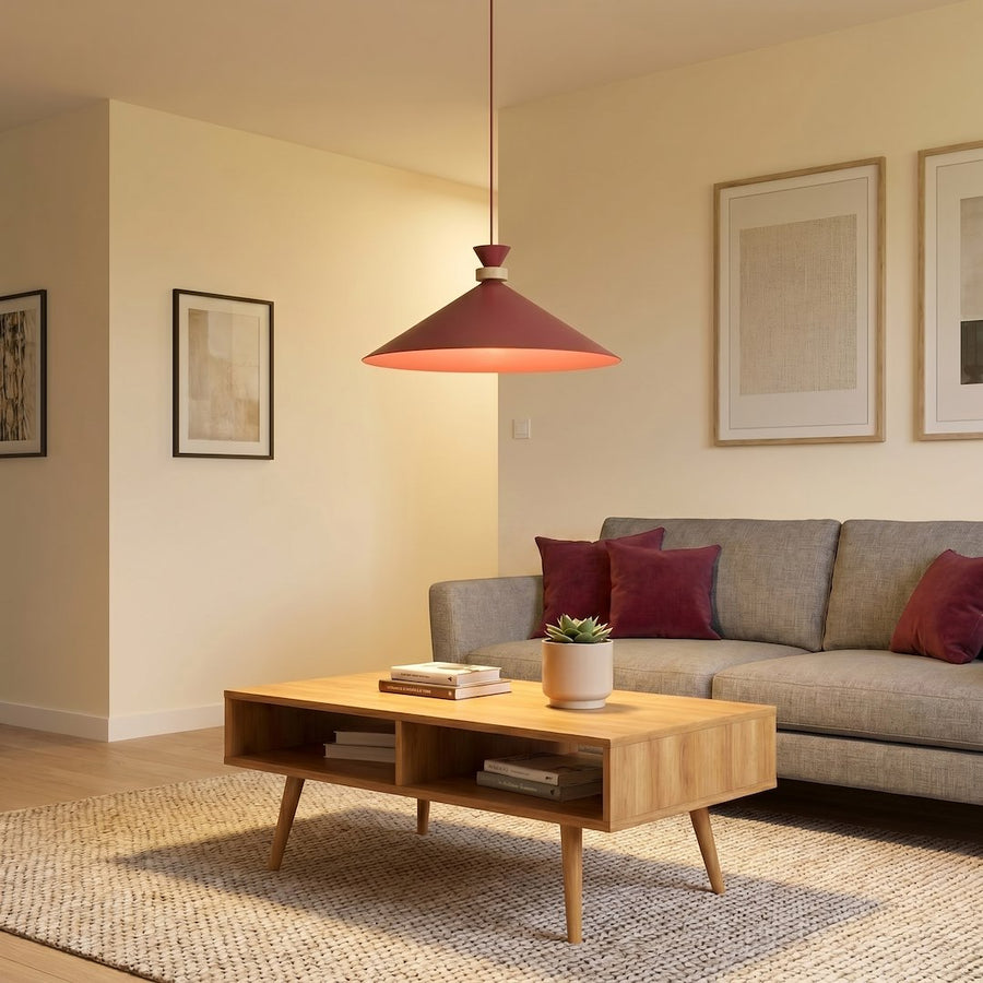 Luminaire allumé au-dessus d'un salon gris avec coussins et table basse claire