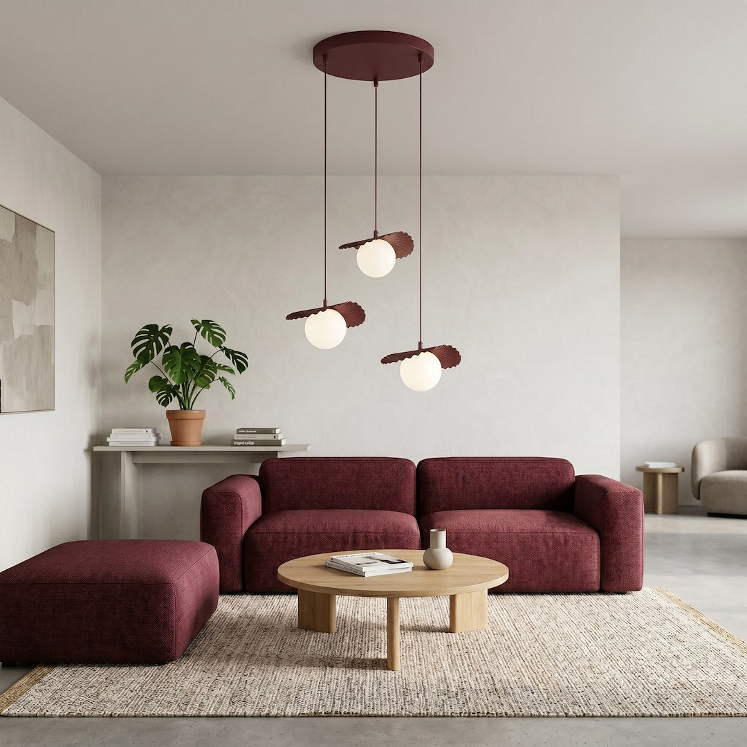 Ambiance salon moderne, suspension allumée au-dessus d'un canapé bordeaux