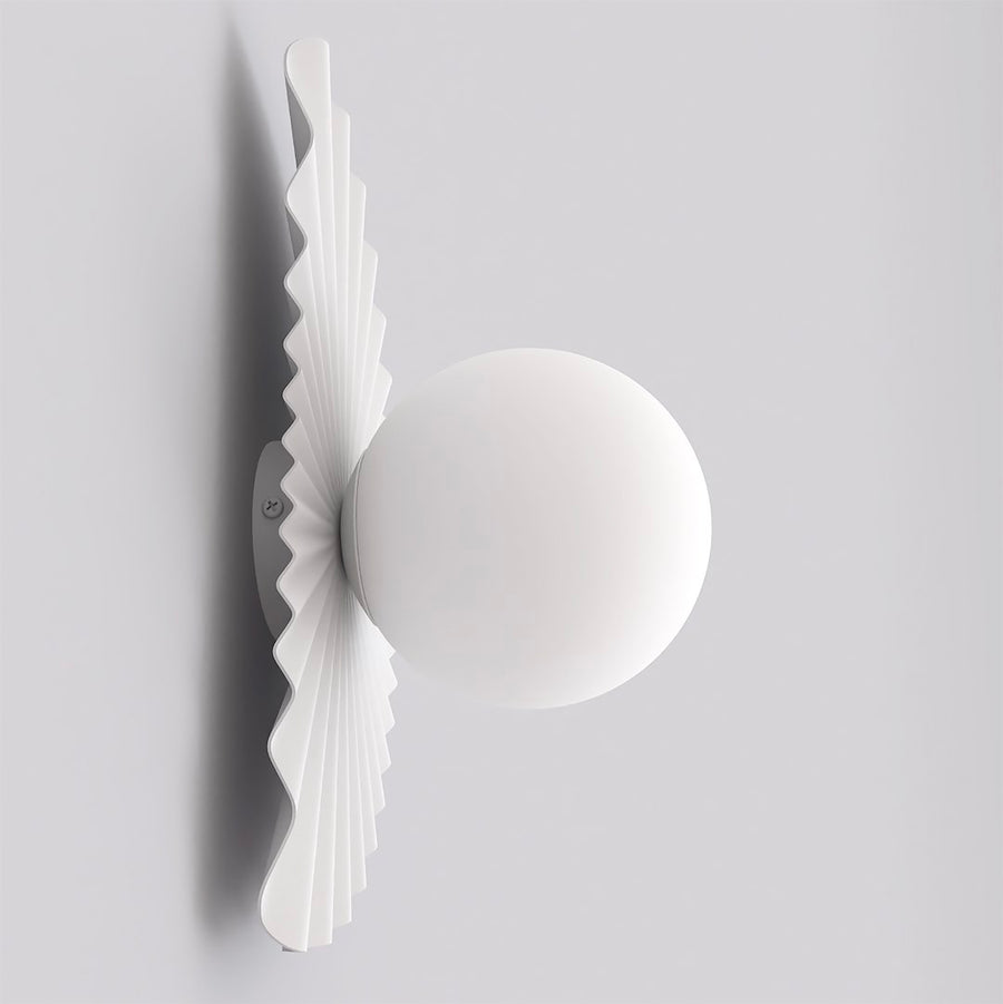 Vue de profil de l applique murale blanche montrant son diffuseur rond et sa platine plissée.
