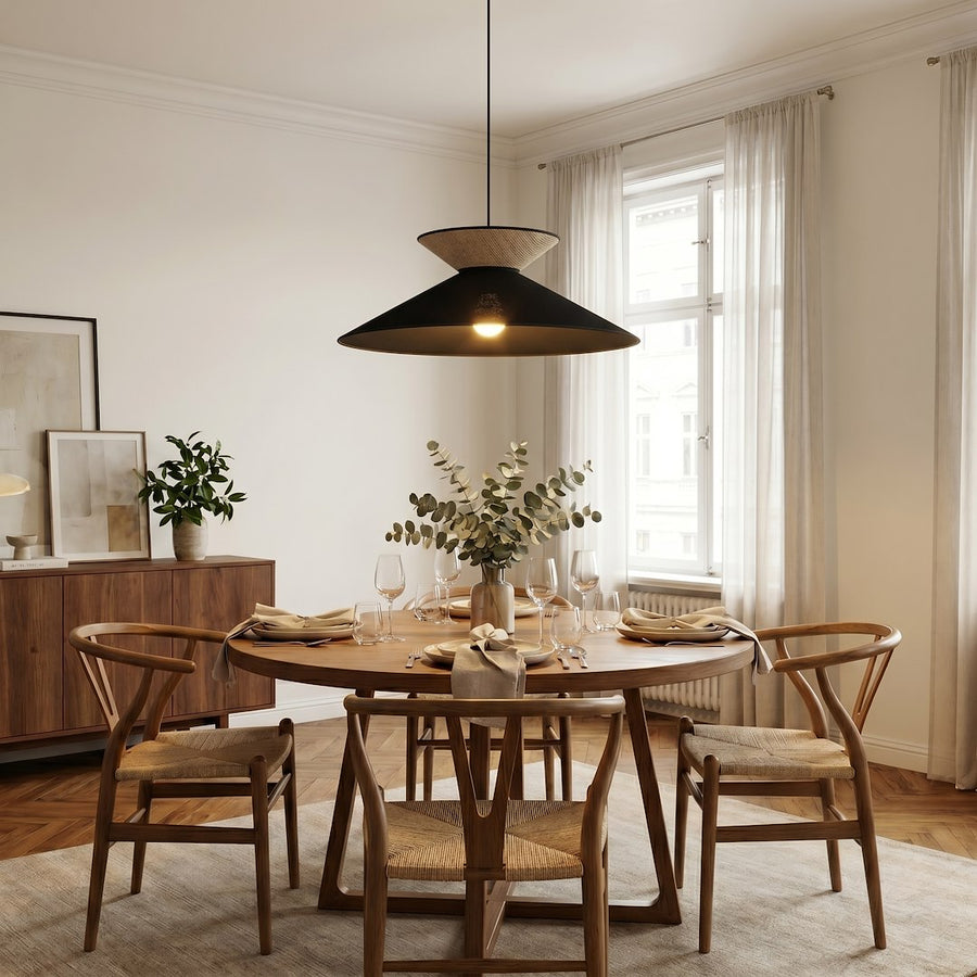 Salle à manger en bois clair, luminaire suspendu au-dessus de la table ronde dressée