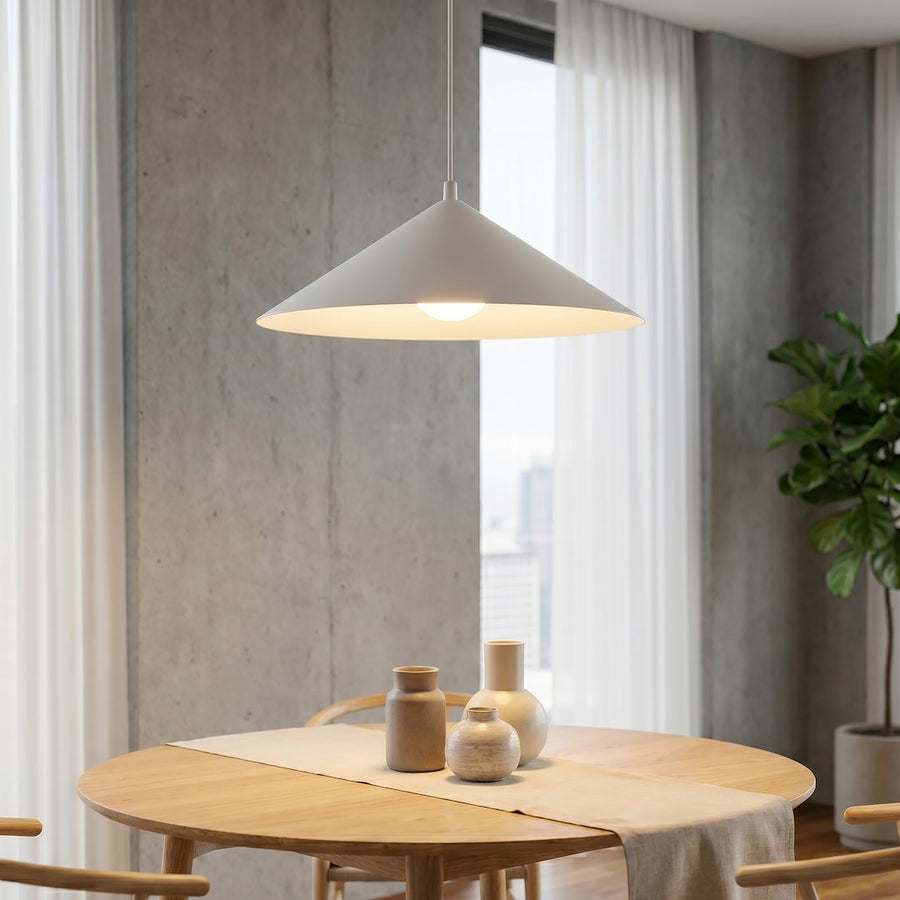 Gros plan sur l'abat-jour conique diffusant une lumière chaude sur la table
